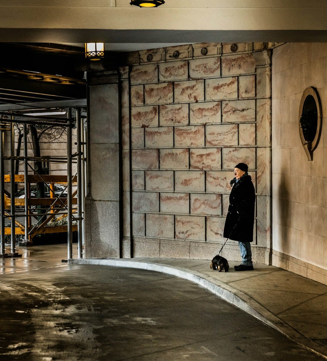 traveling with your service dog — a man standing next to a dog on a sidewalk