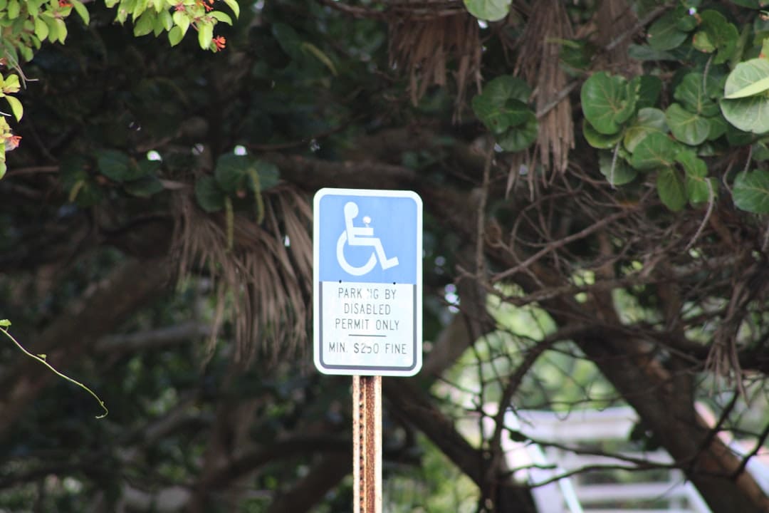 federal laws. A blue and white handicap parking sign next to a tree