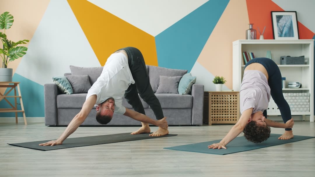 sick service dog — Couple practicing yoga poses in a living room.